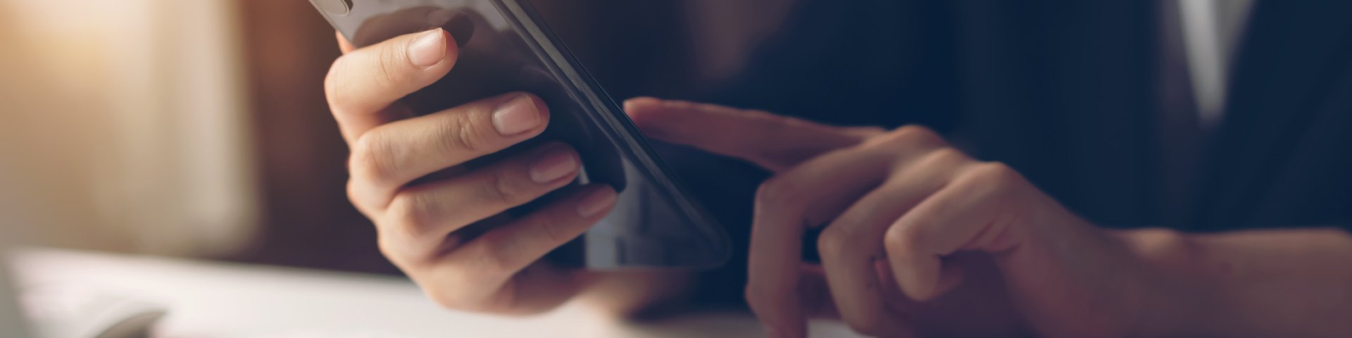 Person using smartphone to contact The Furniture Store in the Brighton, MI area